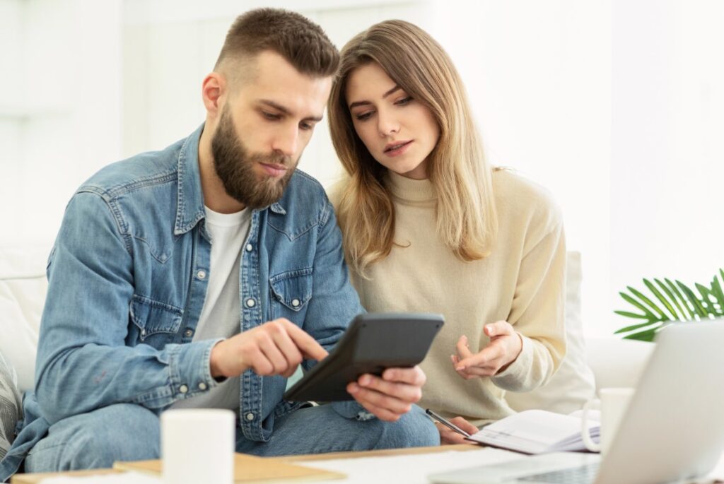 Couple with a calculator trying to work out how much it will cost to remortgage